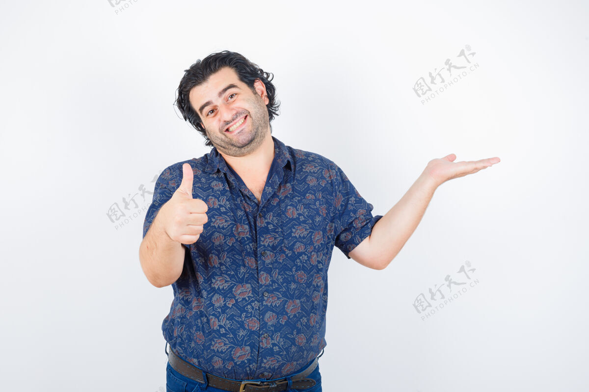 成熟身穿衬衫的中年男子拿着什么东西 同时竖起大拇指 看上去很高兴 正前方视图人人衬衫