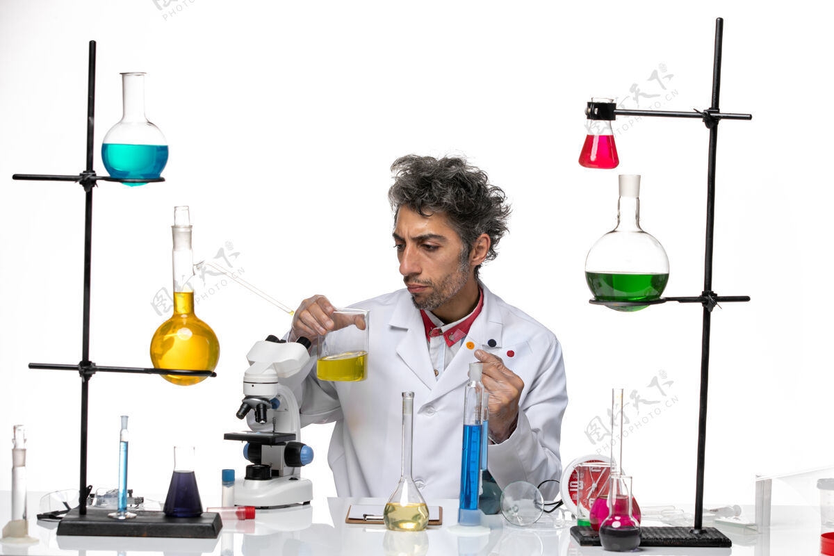 持有正面图男性科学家拿着白色背景的冠状病毒健康实验室的样品和溶液高尔夫样品实验室
