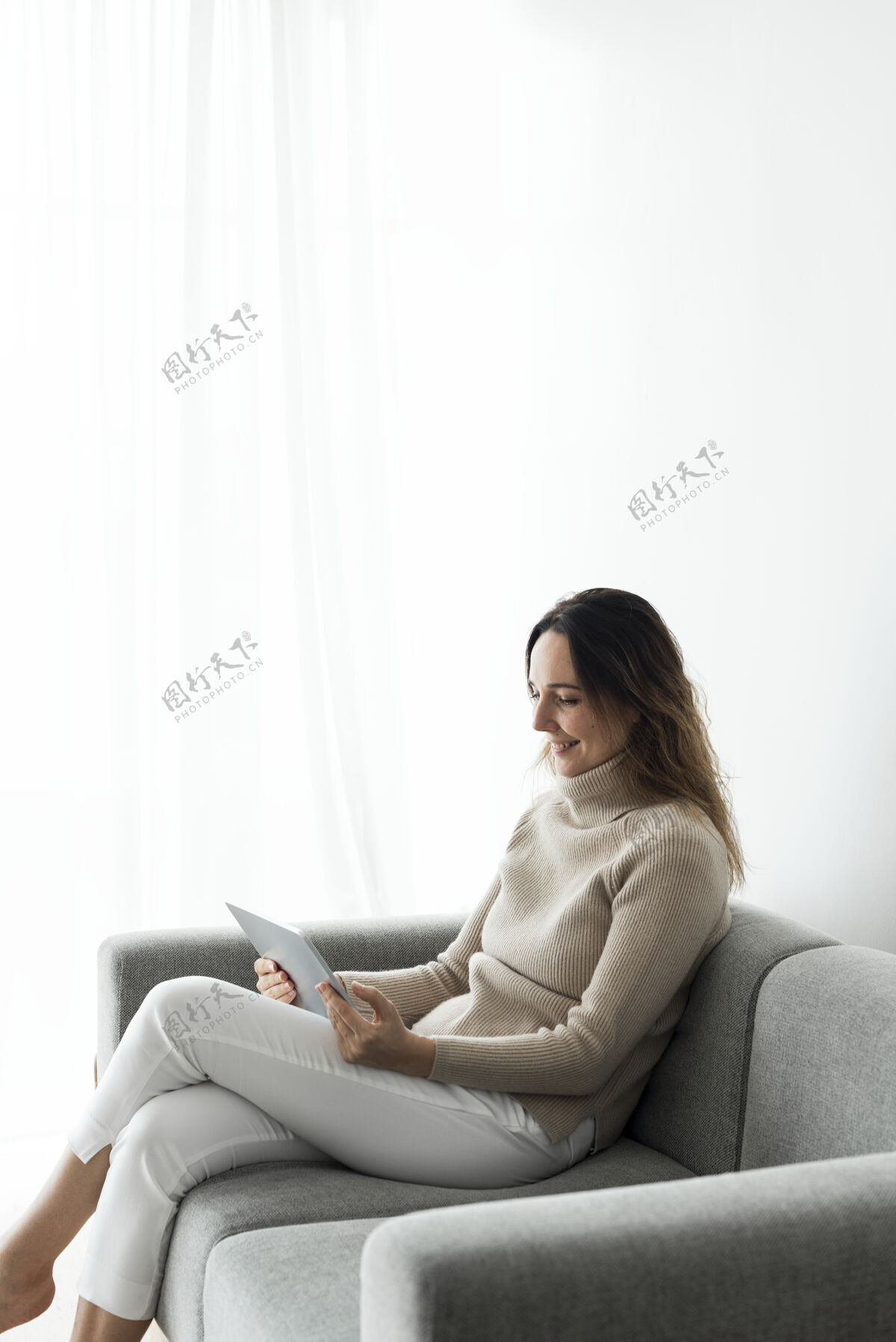 女人在沙发上使用数字平板电脑的女人沙发客厅周末