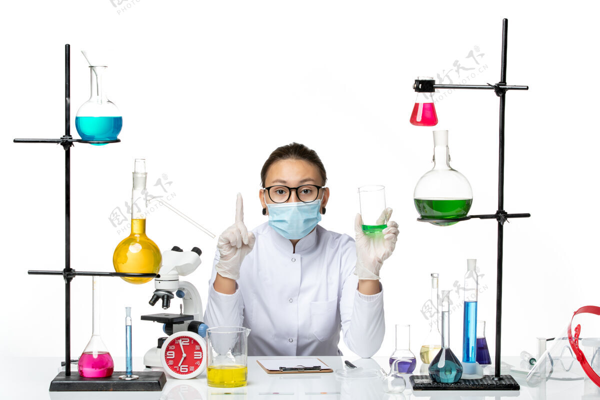 药物正面图白色背景上穿着医疗服的女化学家戴着口罩拿着溶液飞溅实验室病毒化学covid-喷溅专业实验室