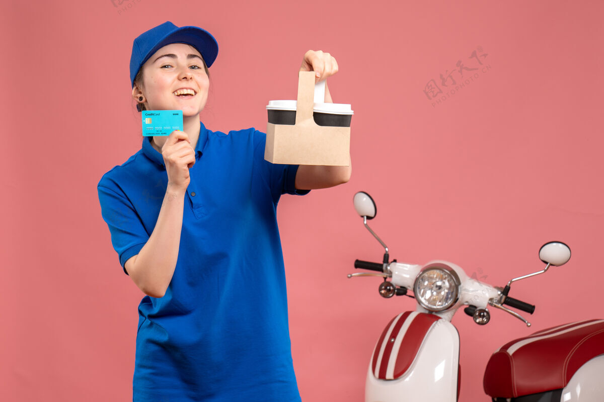 人正面图粉色工作服上的女快递员带着咖啡和银行卡服务工披萨女自行车服务女快递女人