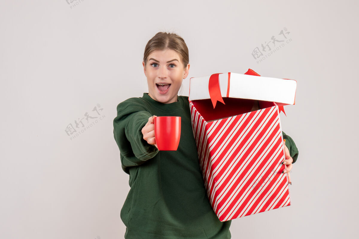 快乐前视图年轻女性 圣诞礼物和一杯茶茶礼物微笑