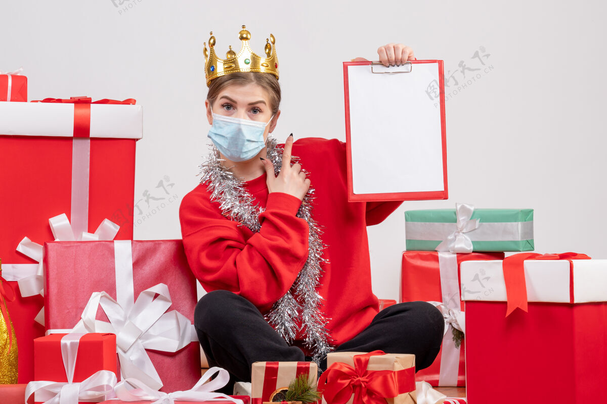 礼物正面图：戴着面具坐着的年轻女性圣诞节桌子人