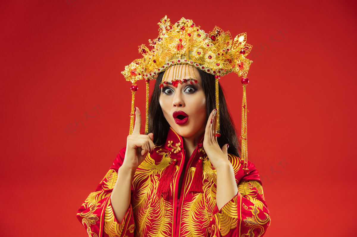文化中国传统的优雅女子在红色背景的工作室里美女指点民间