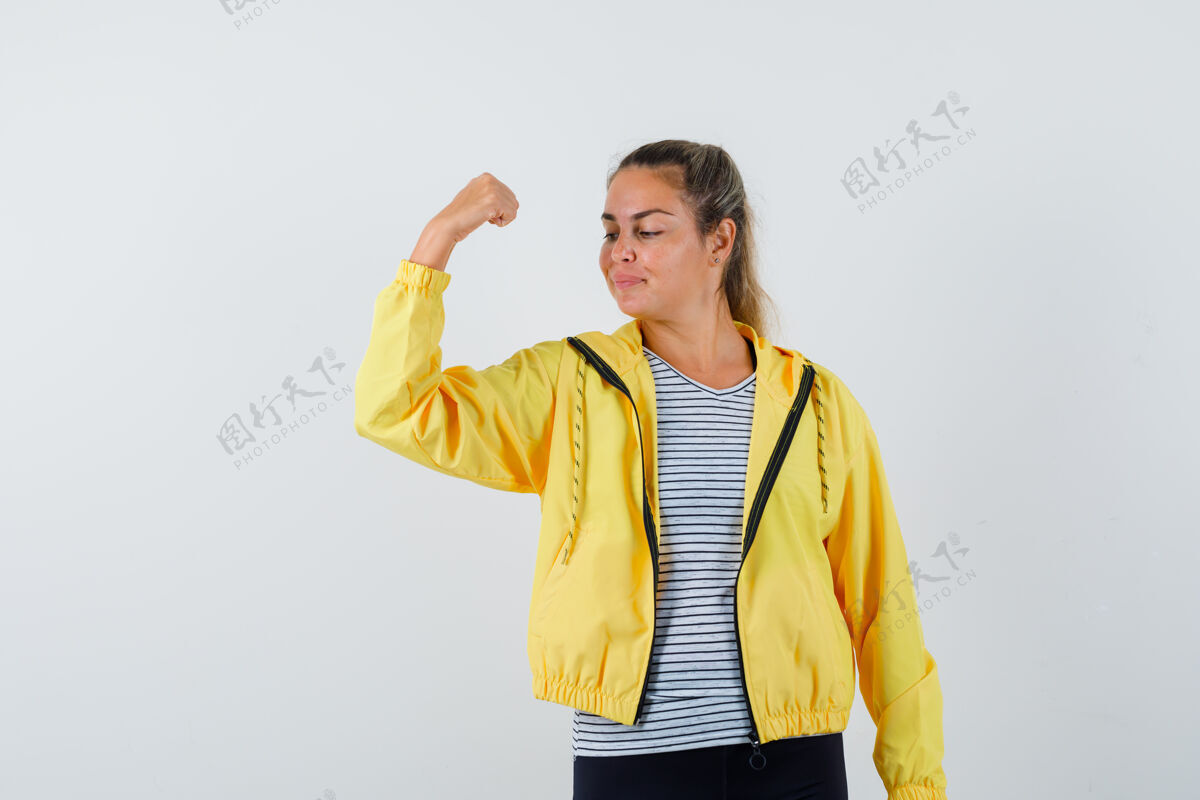 女性穿着夹克衫的年轻女性 t恤展示握紧拳头 看起来很自信 正面视图脸成人年轻