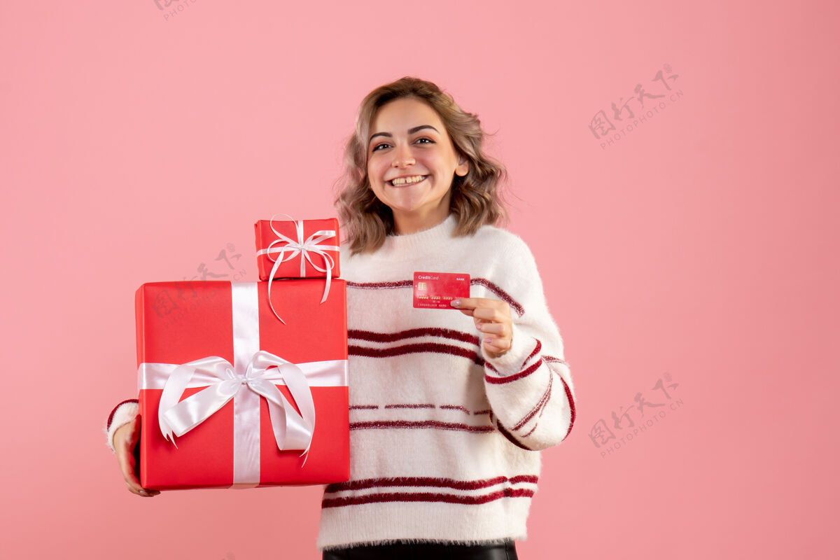 颜色正面图年轻女性手持圣诞礼物和银行卡抱着女人粉色