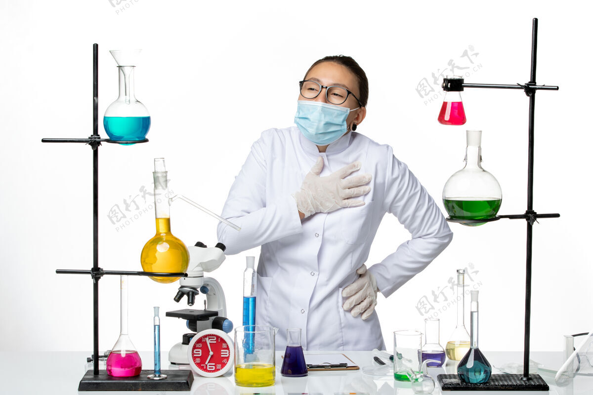 专业正面图白色背景上戴着心痛面具的身着医疗服的女化学家病毒化学实验室病毒-飞溅病毒医学科学