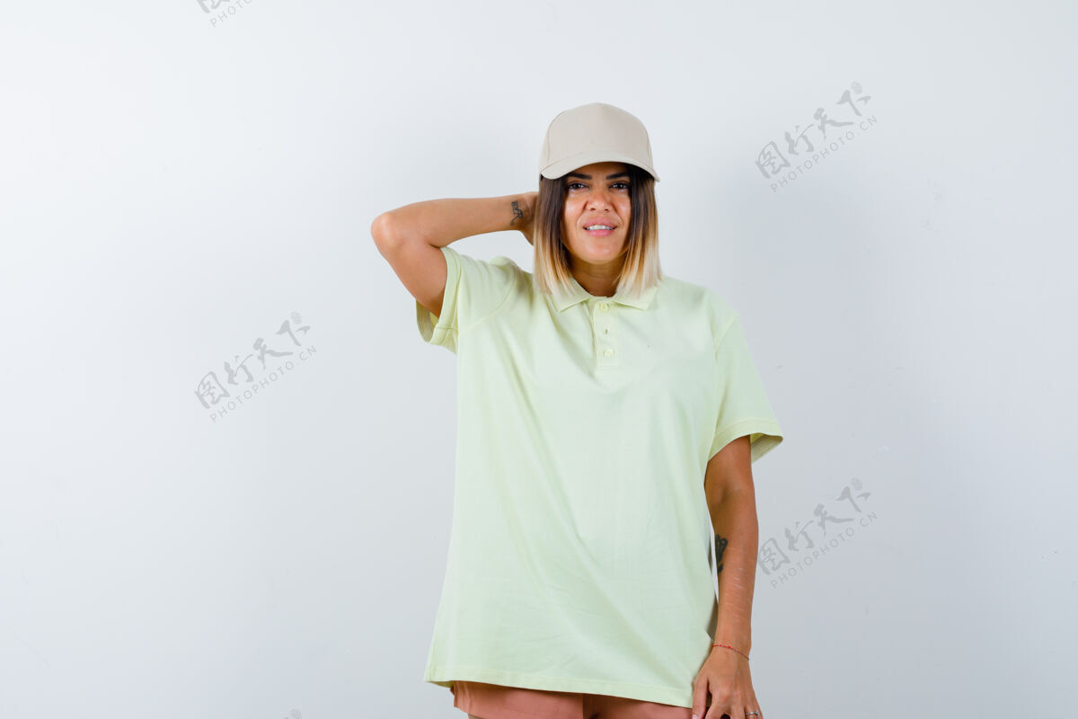 姿势年轻的女士手放在脖子上 穿着t恤 戴着帽子 身材矮小 看起来很自信 正面照护理皮肤时尚