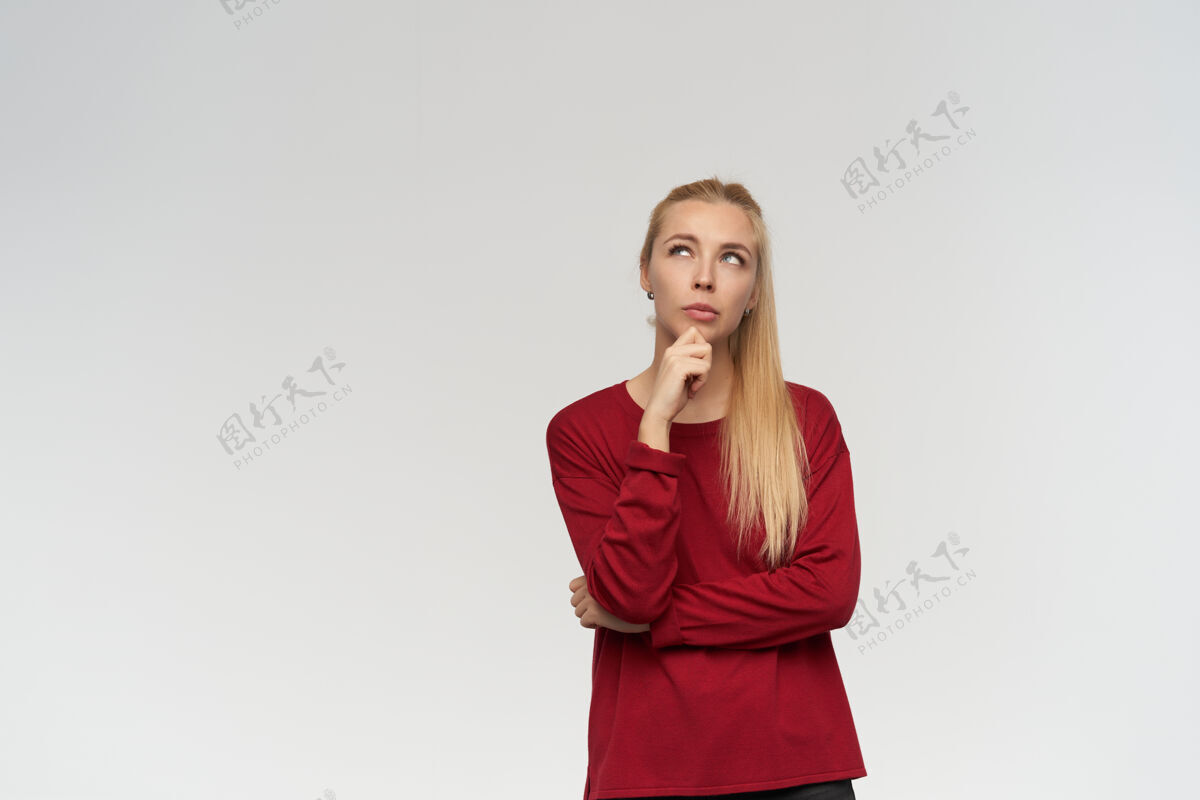 情绪有吸引力的 金发的成年女孩的肖像穿着红色毛衣人和情感的概念在复制空间深思熟虑地看着 在白色背景下孤立成人女孩毛衣