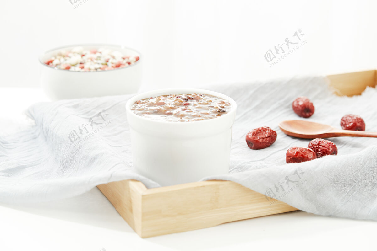 谷物特写的粮食汤在一个碗里用勺子在一块白布在一个木制托盘传统的勺子花生