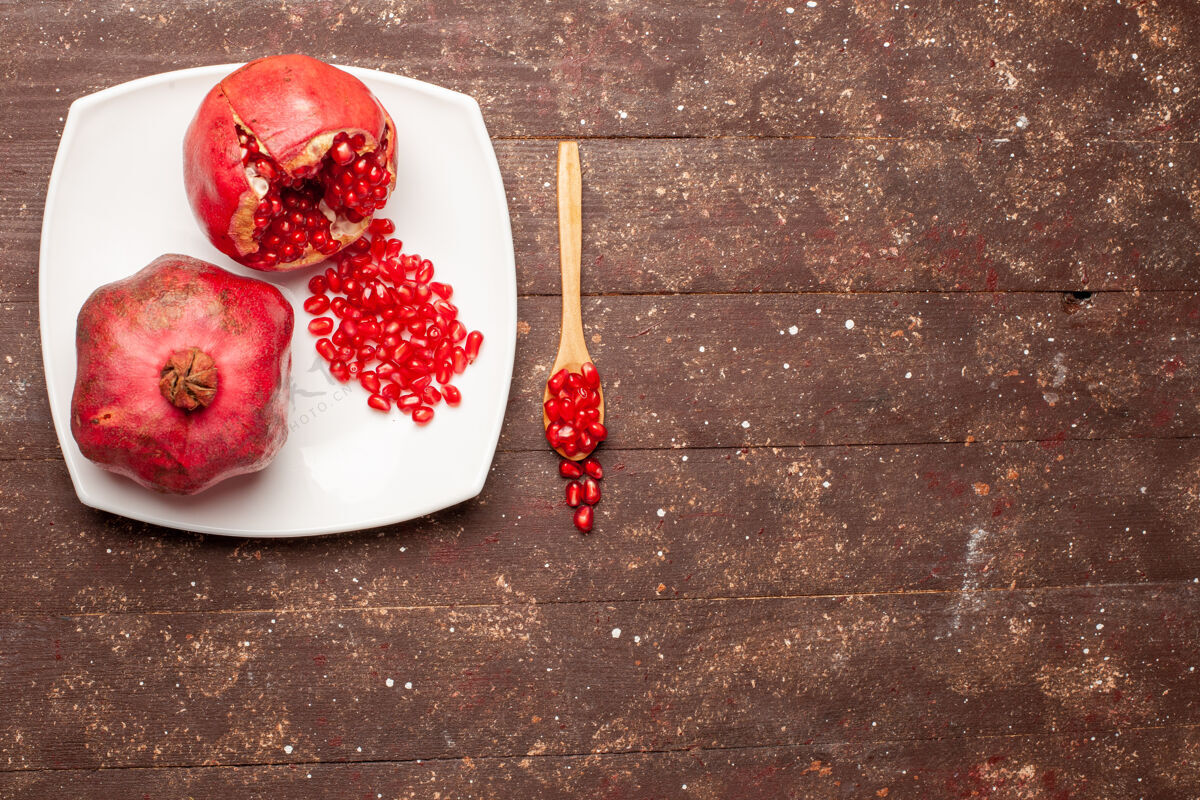 浆果顶视图新鲜的红色石榴在一个棕色的乡村书桌板内黑莓乡村果汁