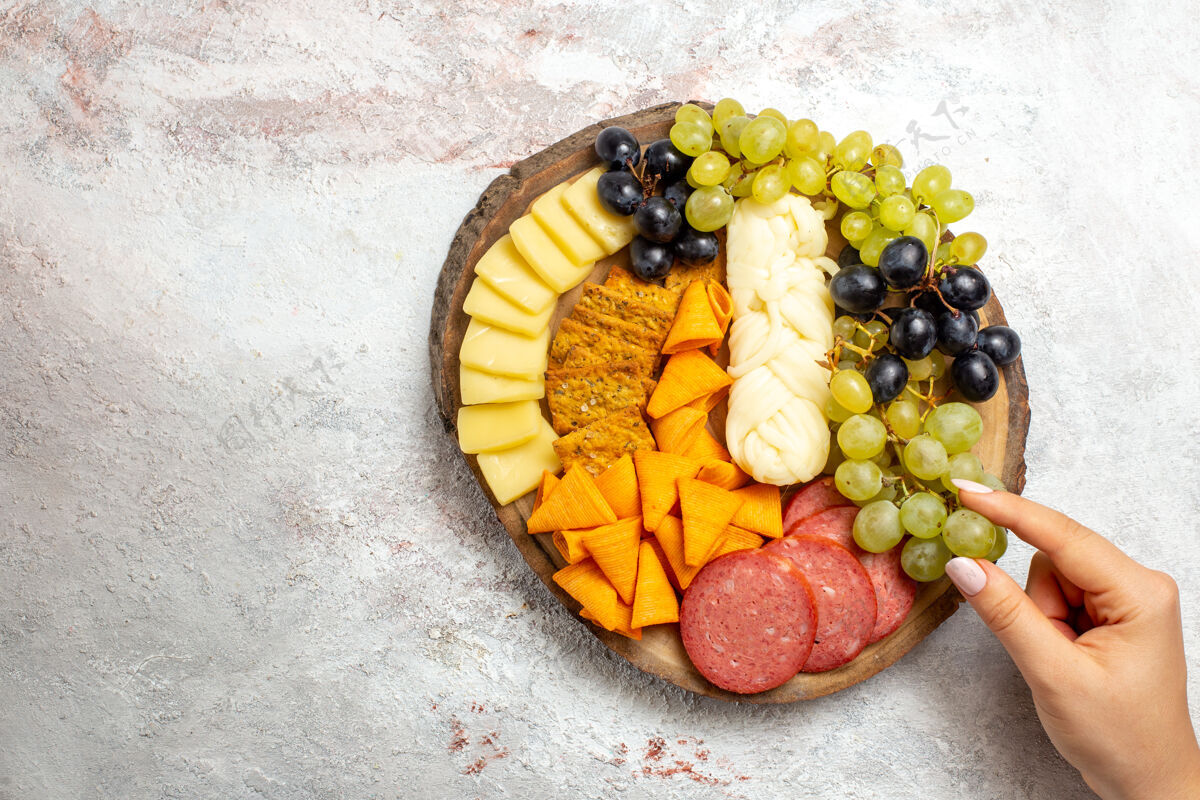 葡萄顶视图不同的小吃cips香肠奶酪和新鲜葡萄在一个空白的空间生的桃顶
