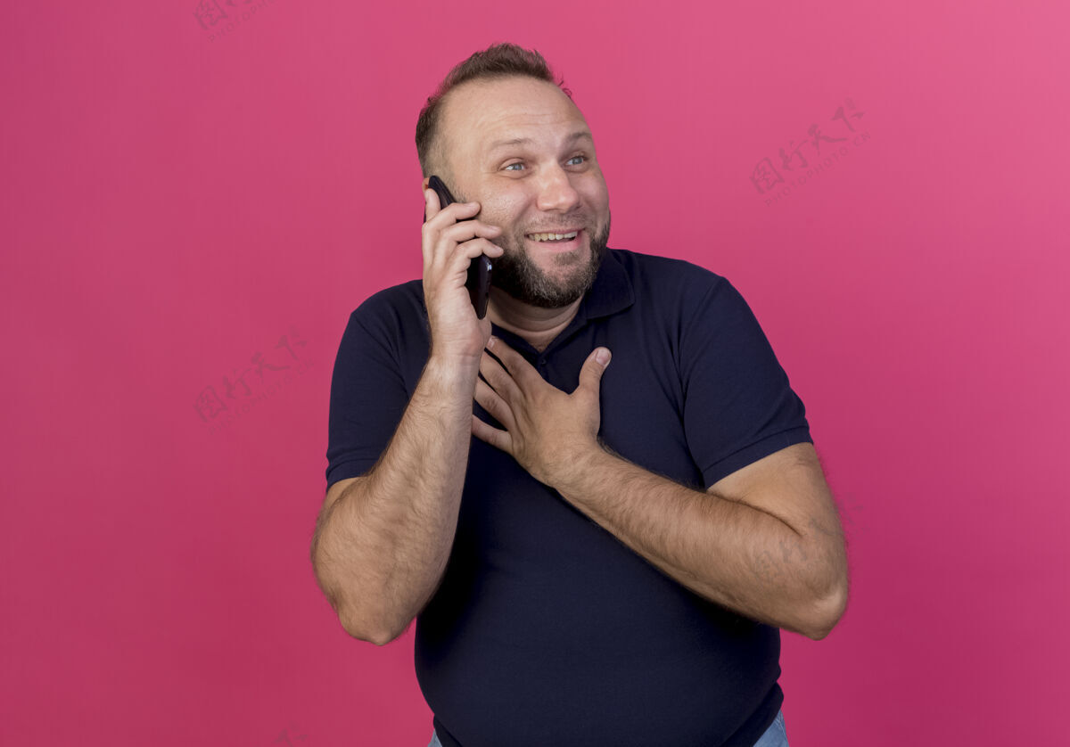 壁板面带微笑的成年斯拉夫男子一边看一边讲电话一边把手放在胸前男人电话人