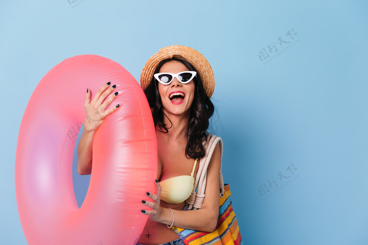 快乐兴奋的戴墨镜的女士拿着游泳圈充气人放松