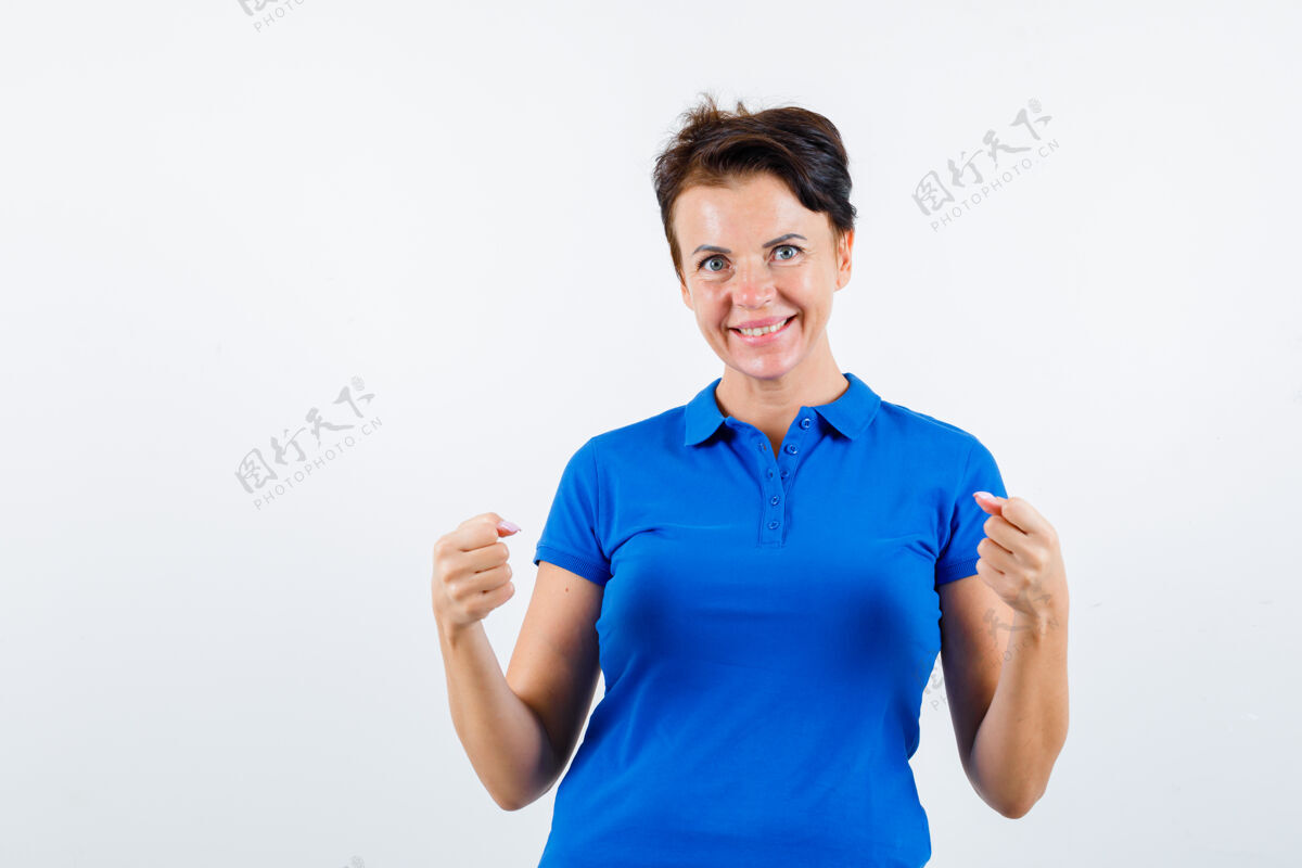 头发身着蓝色t恤的成熟女性展示赢家姿态的肖像 正面看起来很幸福女士微笑老年人
