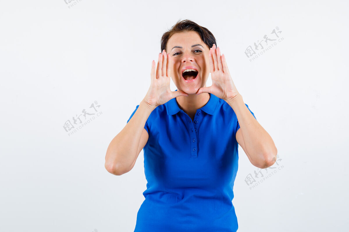 人成熟的女人大声喊叫或宣布某人穿着蓝色t恤 看起来很兴奋 正面视图漂亮微笑肖像