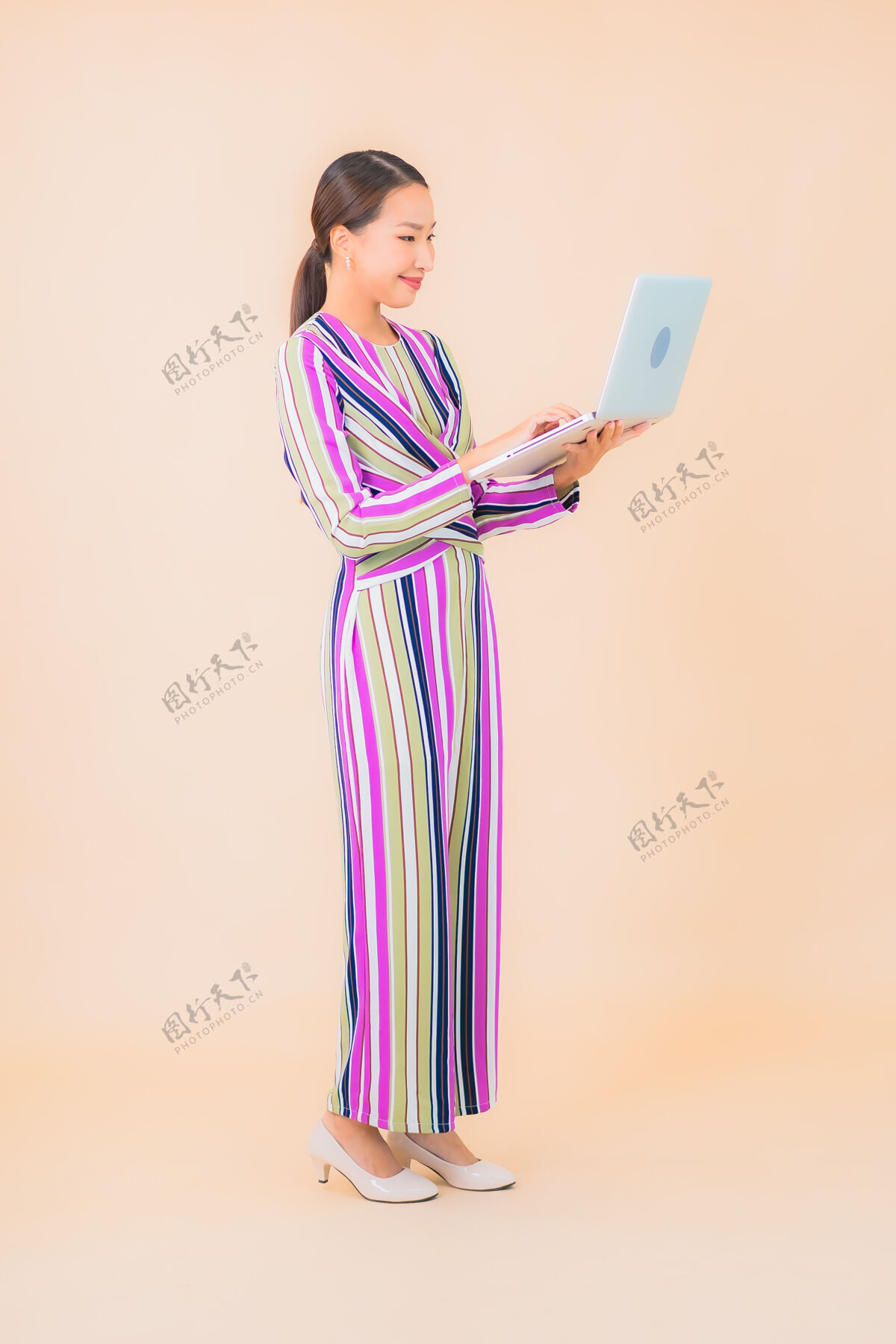 中国人用彩色笔记本电脑描绘美丽的亚洲年轻女子无线数据工作