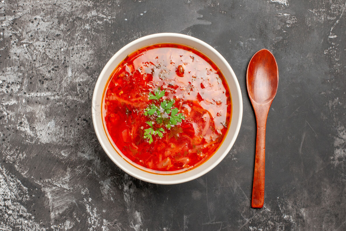 汤黑色表面上美味的罗宋汤红色蔬菜汤的俯视图西红柿蔬菜午餐