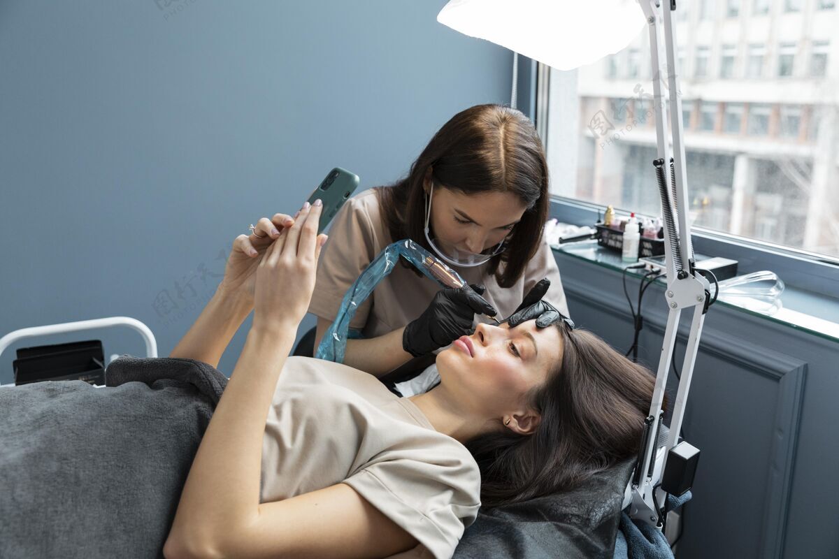 护理美容师正在为她的客户做眉毛护理治疗客户美容