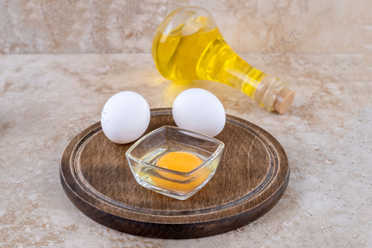 蛋白质一块生鸡蛋木板和一瓶玻璃油鸡蛋美味食物