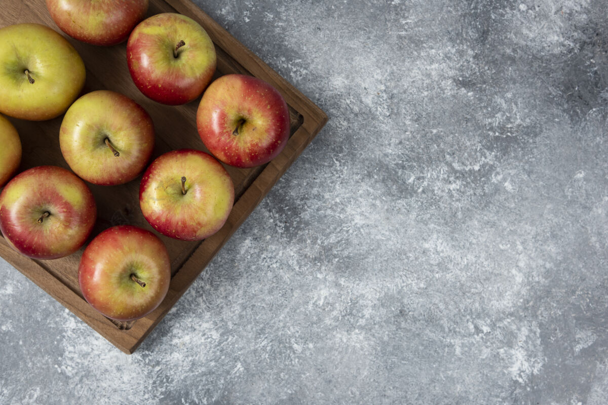 营养用新鲜美味的苹果做成的木板放在大理石表面顶视图苹果收获