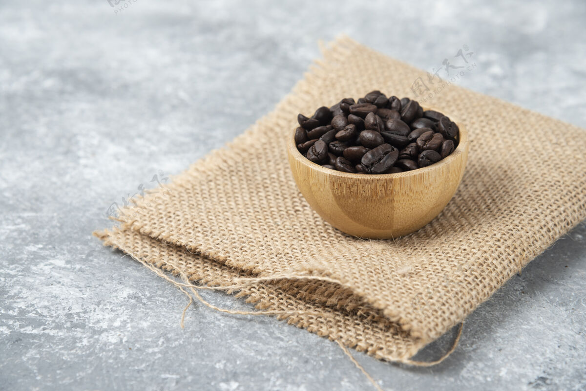 豆子在大理石上的木制碗里烤咖啡豆全麦粗麻布自然