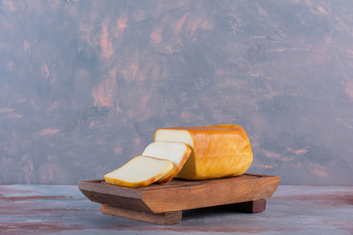 板长方形的奶酪片放在木板上 放在大理石背景上美味盘子牛奶