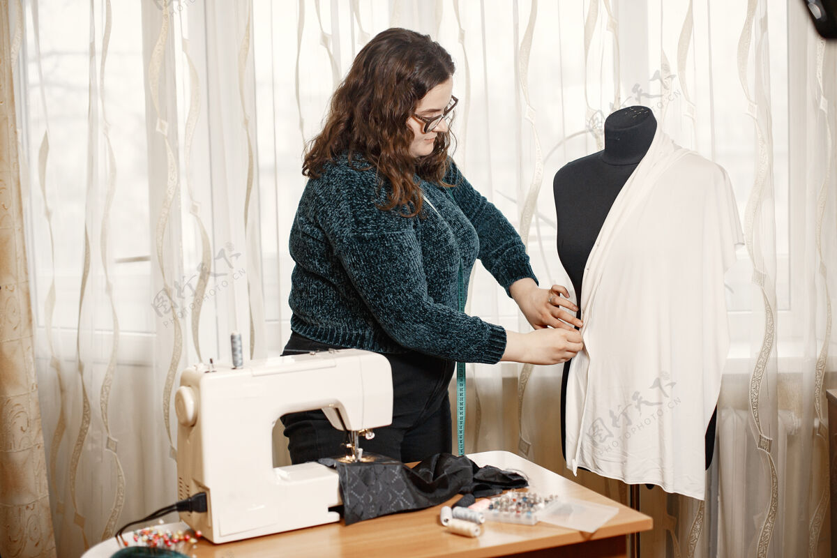 手缝纫衣服的工具女人和眼镜一厘米长的女裁缝专业衣服工作场所