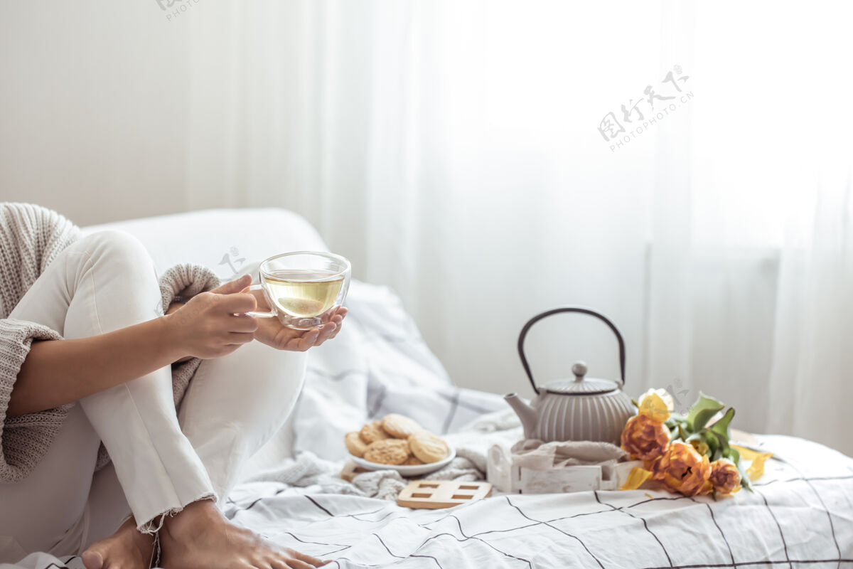 静物茶水 饼干和一束新鲜的郁金香放在床上美味舒适休息日