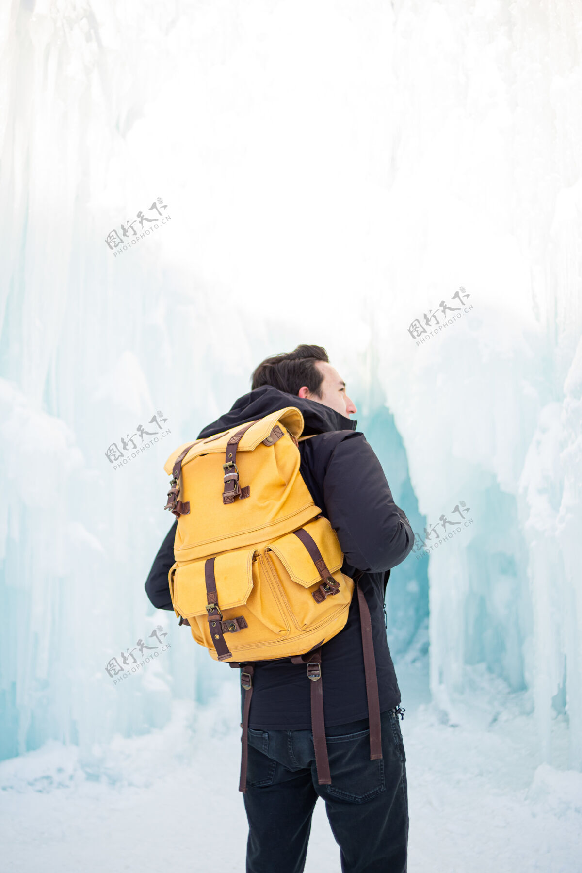 下雪一个穿着黑色夹克和棕色背包的男人站在雾蒙蒙的森林里冬天背包寒冷