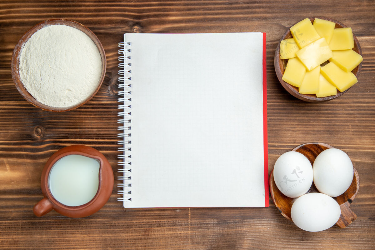 蛋壳顶视图生鸡蛋加牛奶和切碎的奶酪放在餐桌上吃早餐面团牛奶鸡蛋游戏设备