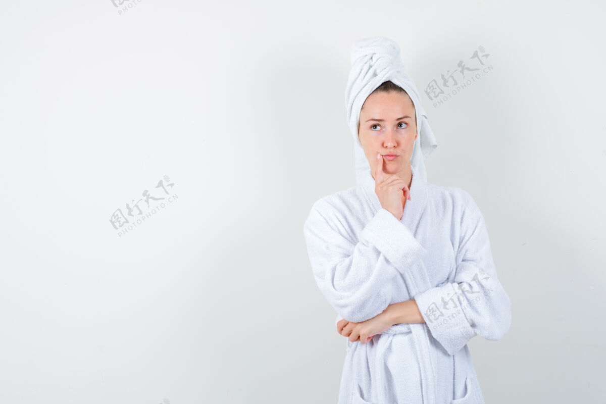 年轻穿着白色浴袍的年轻女子 手巾放在嘴边 面带沉思 俯视前方成人手指微笑