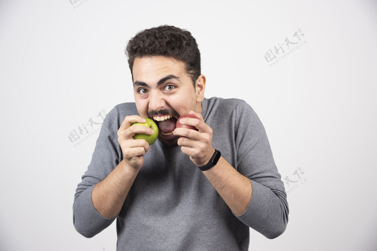 休闲黑发男人吃青苹果和红苹果食物水果苹果