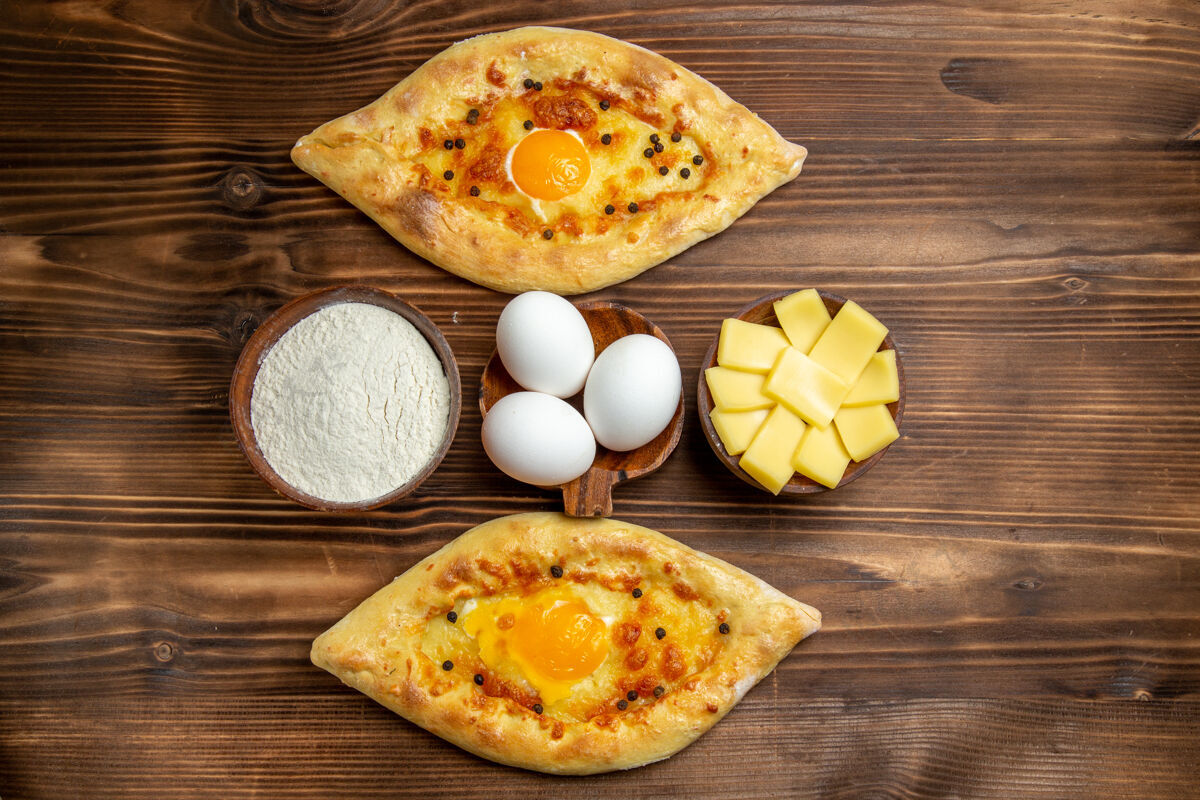 晚餐顶视图烤鸡蛋面包从棕色木制桌子上的烤箱新鲜的面团鸡蛋面包早餐午餐奶酪烘焙