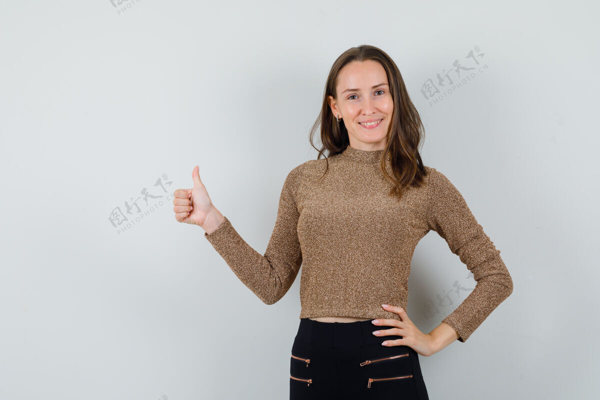 女性年轻女性穿着金色上衣竖起大拇指 看起来很自信正面图魅力成人人