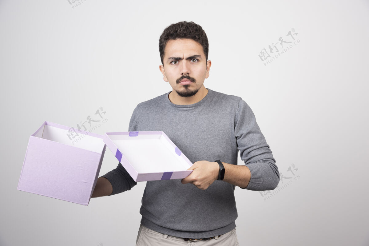 模特一个在白墙上打开紫色盒子的令人震惊的人男人男人男孩