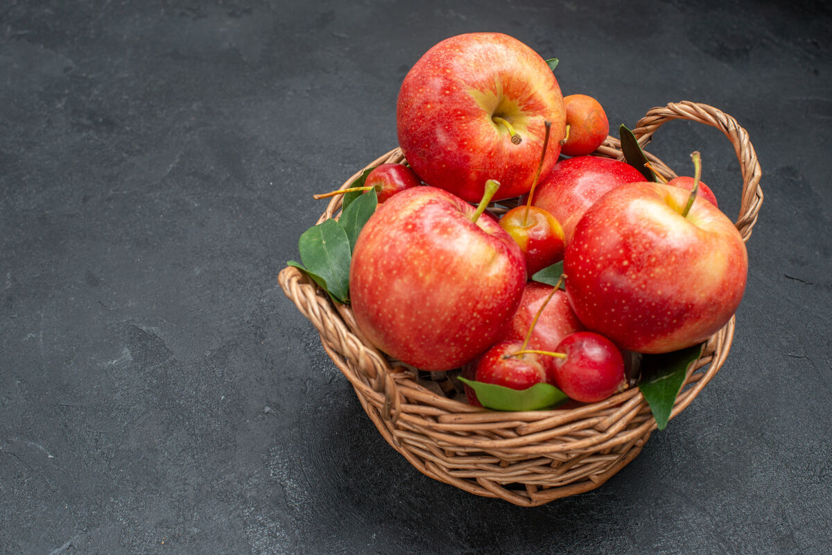 樱桃侧面特写镜头可以看到水果篮里的开胃苹果和樱桃多汁篮子吃苹果