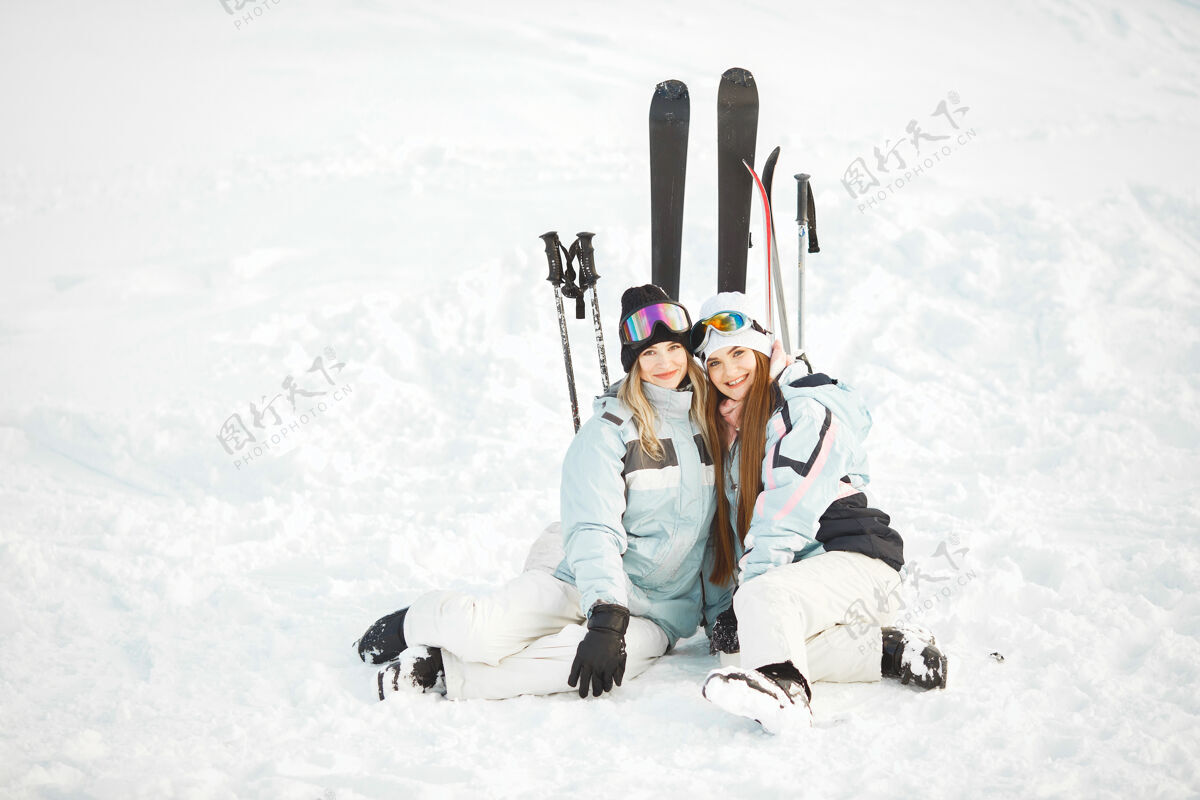 红色女孩们在雪地里滑雪 享受拍照的乐趣 在山上度过时光下雪站立黑发