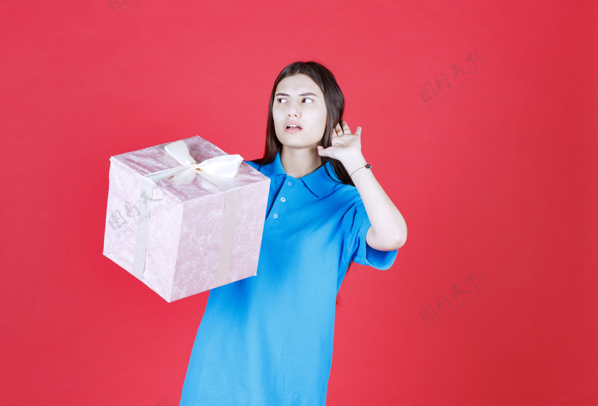 休闲一个女人拿着一个紫色的礼盒 叫人过来接受它邀请喊叫询问