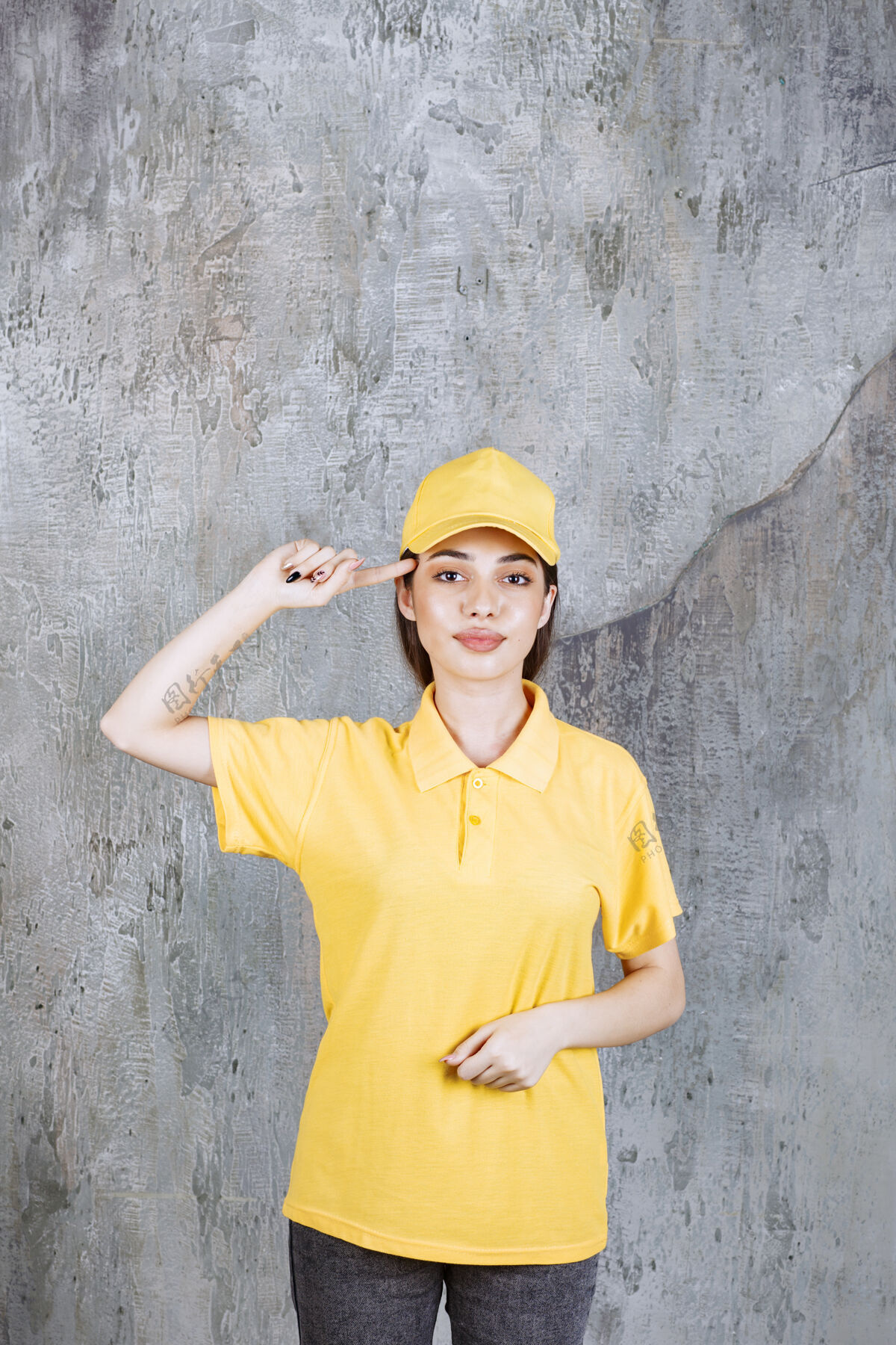 成年人身着黄色制服的女服务人员站在水泥墙上 看上去很体贴快递员工人姿势