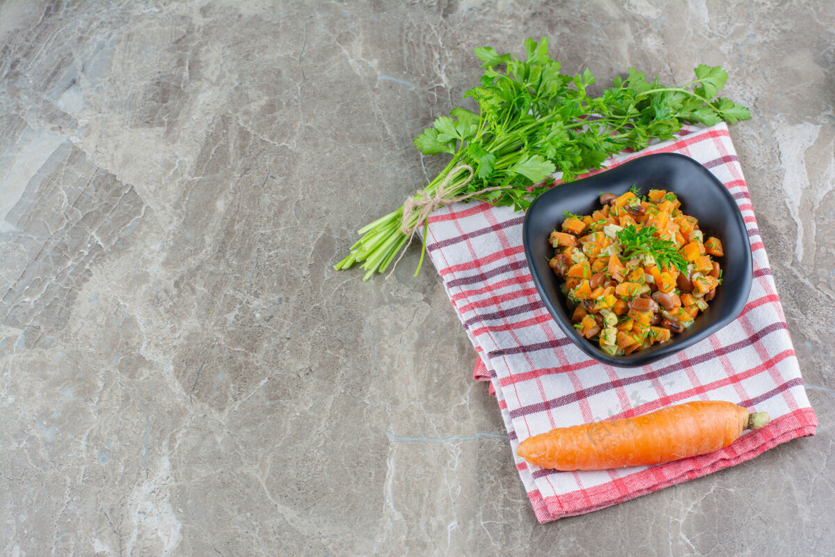 碗欧芹 胡萝卜和烤豆放在碗里 放在大理石桌上的茶巾上茶毛巾美味美味