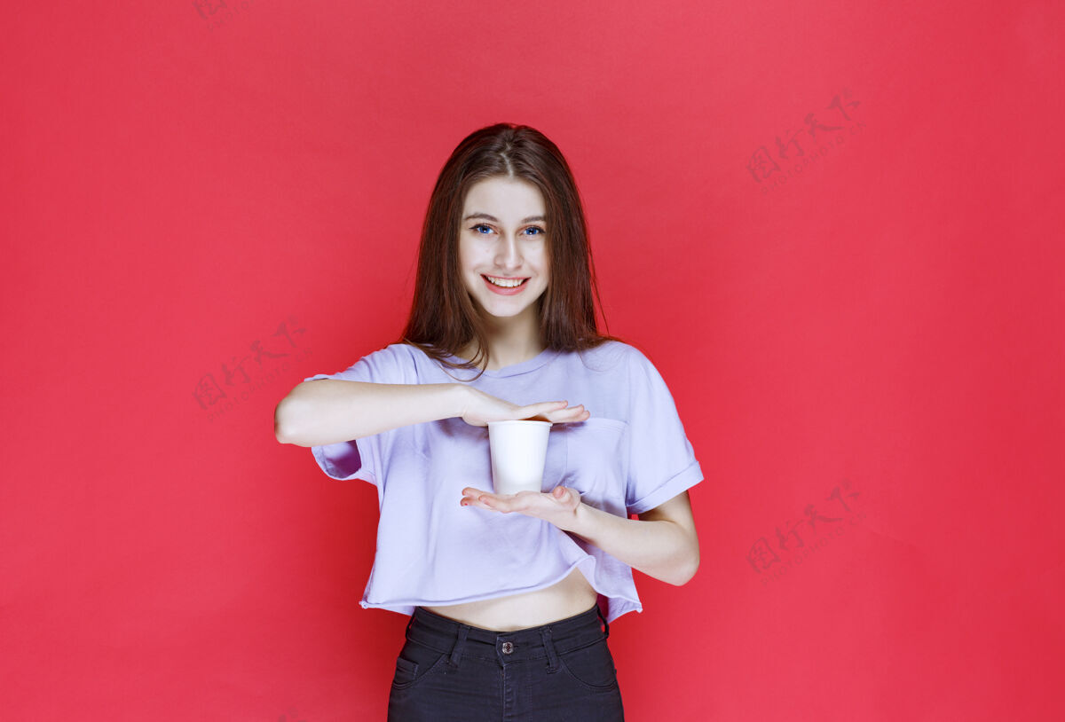 姿势手持白色一次性水杯的年轻女子塑料咖啡外卖