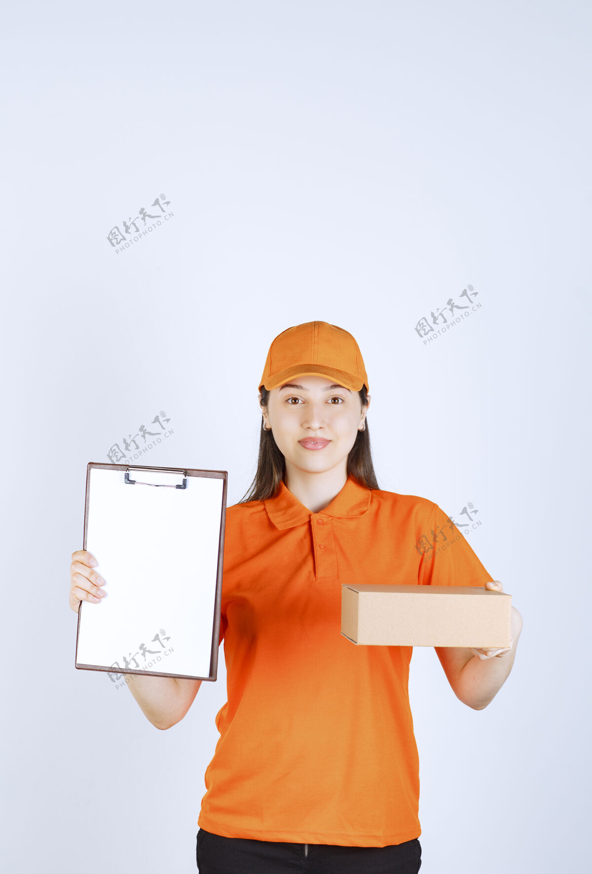 送货员身着橙色制服的女服务人员手持一个纸板箱 出示一份清单供签字送货员空白快速