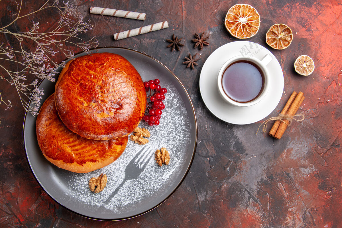 早餐俯瞰美味的馅饼和一杯茶在一张深色的桌子上甜甜的糕点馅饼糕点健康柑橘