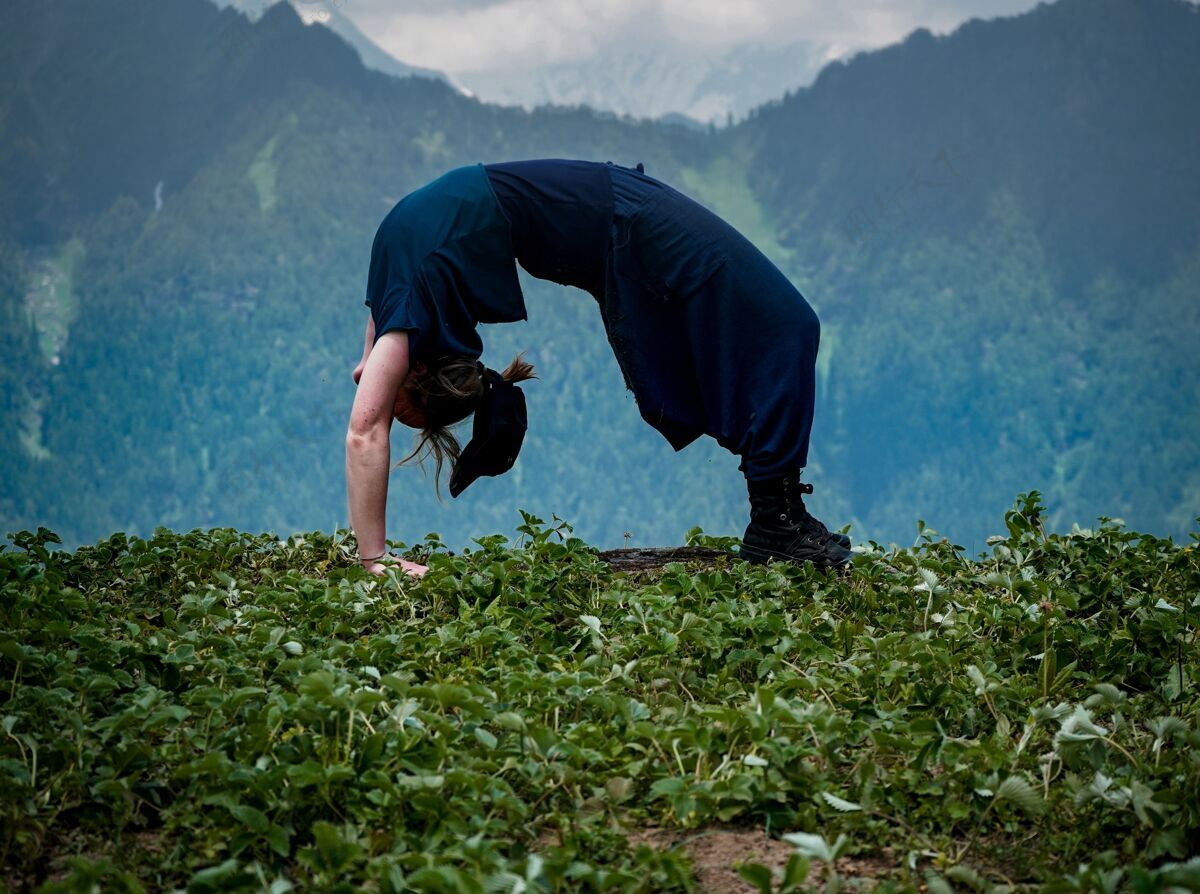 场景年轻女子在自然环境中做瑜伽练习白天公园草地