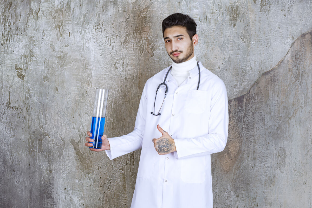男人男医生 带听诊器 手持装有蓝色液体的化学瓶 手部有成功的迹象保证医生实验室