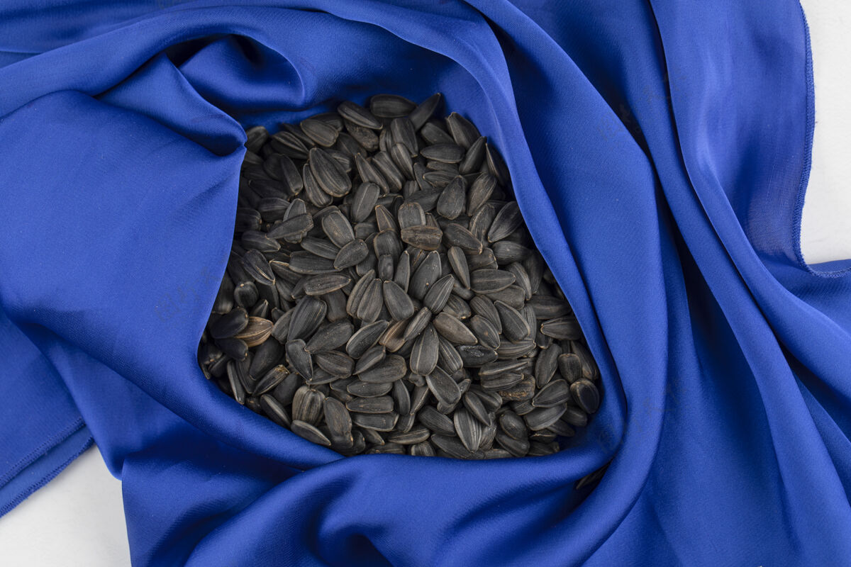 农业一堆向日葵黑籽放在蓝色桌布上仁熟的谷物