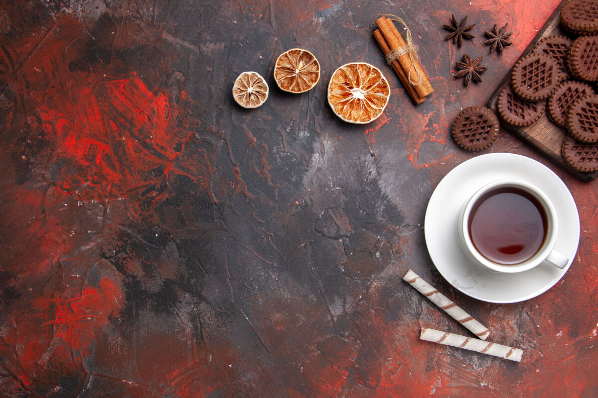 饼干顶视图一杯茶加巧克力饼干放在深色桌子上饼干茶饼干早餐咖啡茶