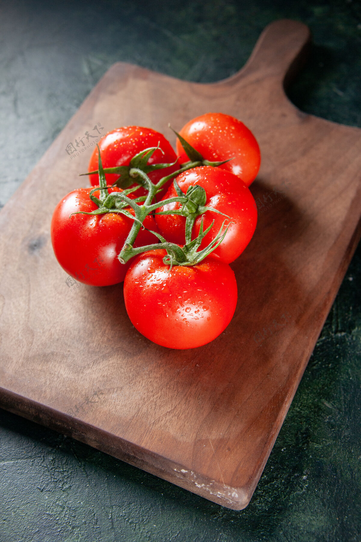 食物前视图新鲜的红色西红柿在砧板上深色的背景深色胡椒粉晚餐
