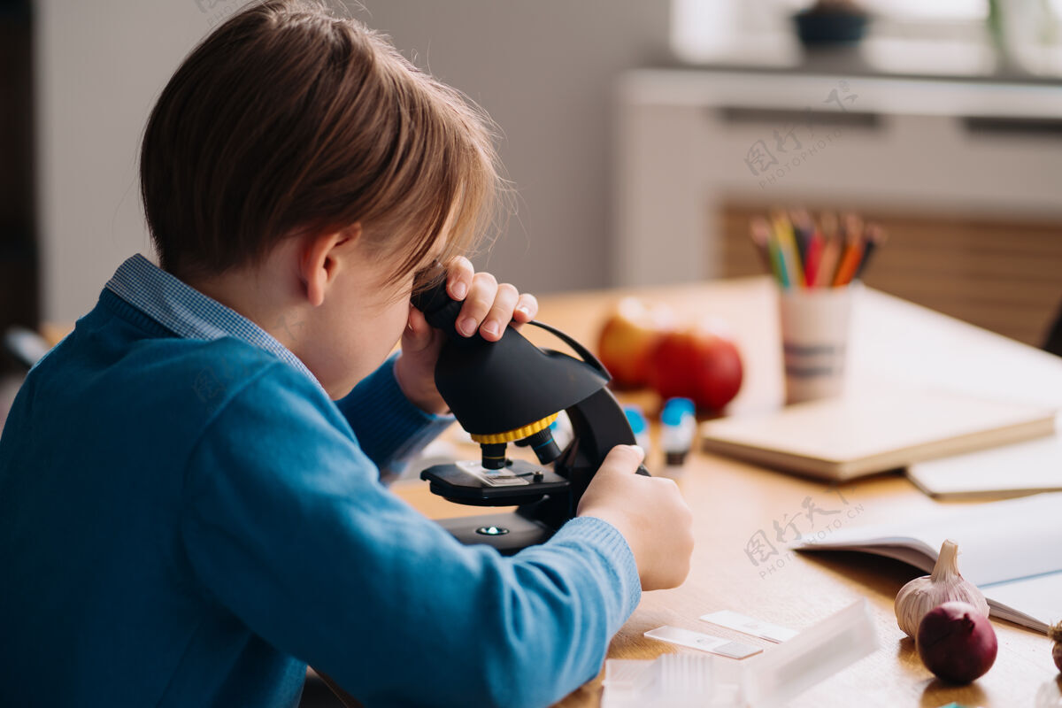 课一年级男生在家用显微镜学习生物人家庭作业
